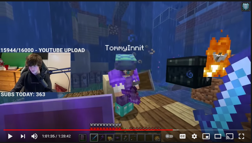 A screenshot from Tubbo's stream. He's standing in the community house wreckage holding a sheild and sword. Tommy stands opposite him, defending access to an ender chest.